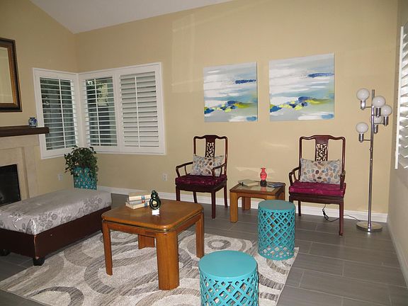 Spacious Living room with fireplace & plantation shutters. Staging furniture & paintings not included. Home may or may not be staged when you go to view the home.