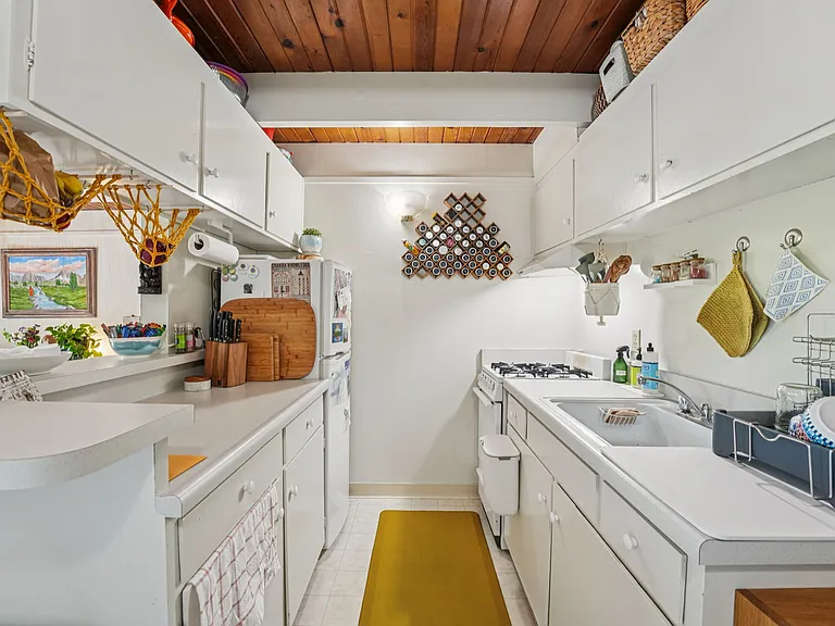 Galley kitchen in the upstairs studios, with views of nature - looks out into the living room and covered private deck.