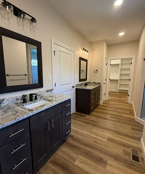 Primary bath with dual vanities, large walk-in shower, separate water closet and expansive walk-in closet