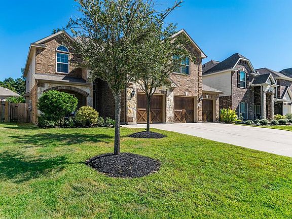 Absolutely stunning front elevation featuring stacked stone and barn style garage doors.