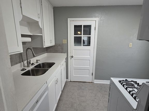 Kitchen view from the dining room, showing new quartz countertop and refurbished cabinets.