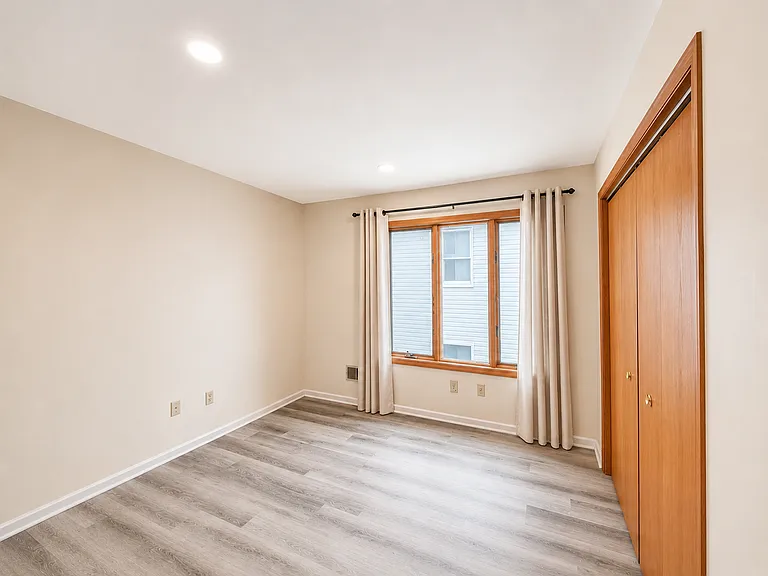 Bedroom with large window and closet storage