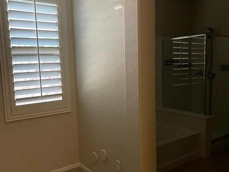 Primary bedroom with archway to primary bathroom.