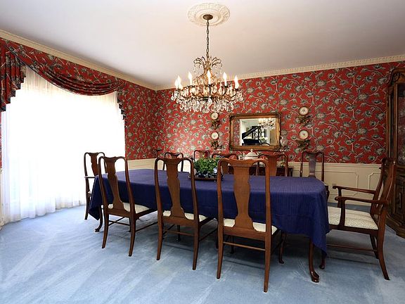 Dining room had crystal chandelier, wainscoting, high ceilings and pocket doors to kitchen. It is large enough for the most elegant dinners and family gatherings.
