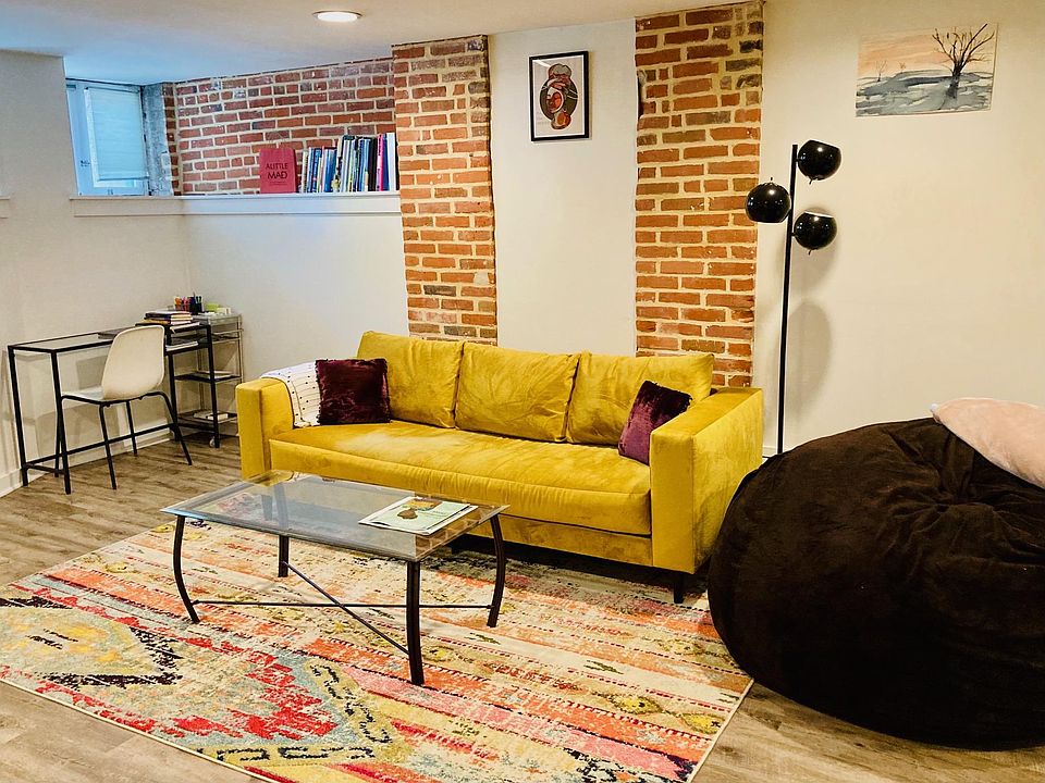 Living room with built-ins and exposed brick.
