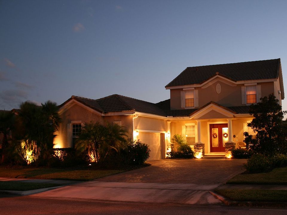 Front elevation featuring brick paver driveway and Spanish tile roof