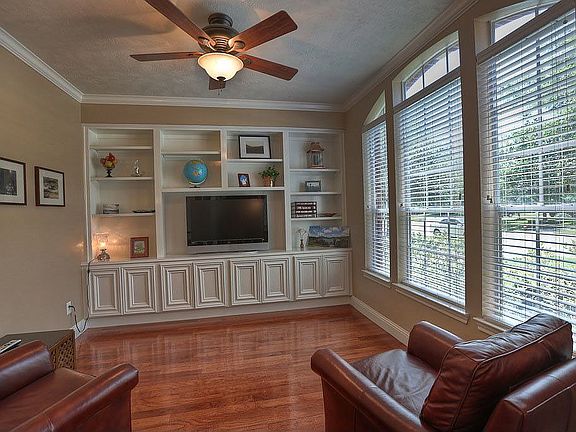French doors open to the study that features custom built-ins and hardwoods