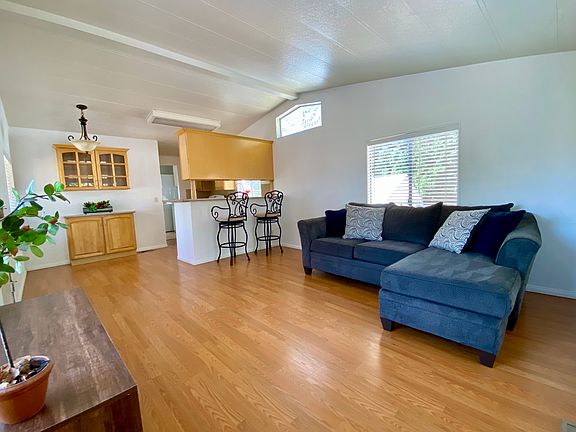 Spacious living room with vaulted ceilings and open floor plan, sofa and barstools could be left for your use!