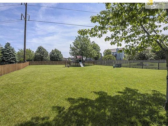 Extra large fenced backyard with play set.