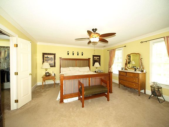 Attractive master bedroom has a large walk-in closet and ceiling fan