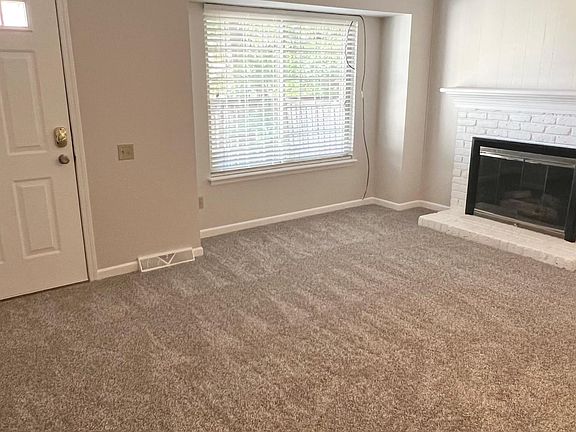 Gas log fireplace and newly installed carpet in front living room.