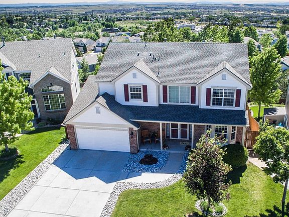 Inviting front porch and double-door entry into vaulted foyer.