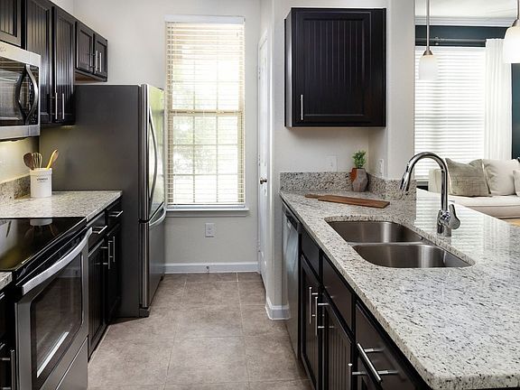 Kitchen with espresso cabinetry, granite countertops, and stainless steel appliances