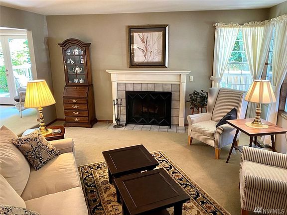 Front living room with a cozy fireplace and natural light.