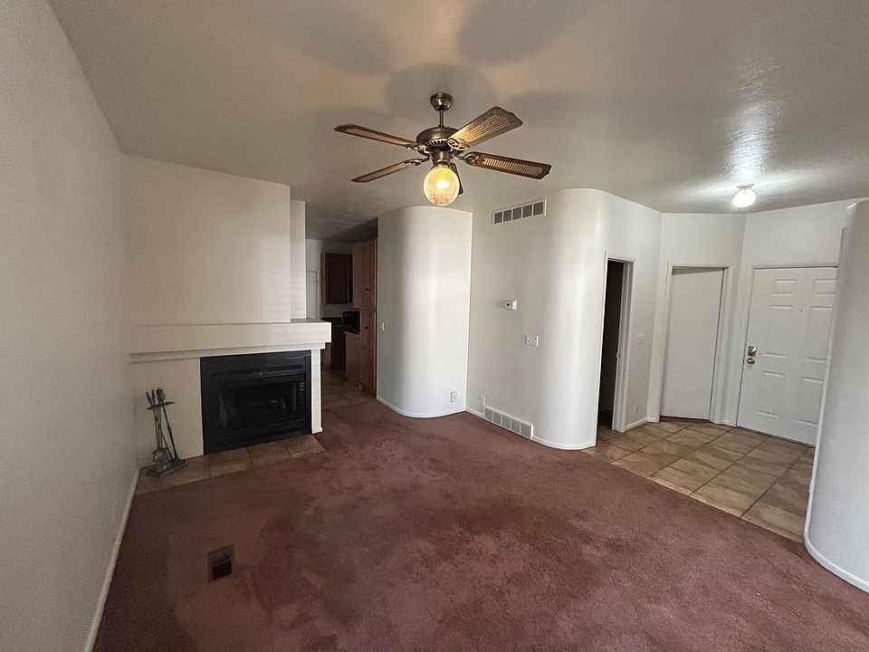 Living room with fireplace, entryway closet and access to both bedrooms and bathroom.