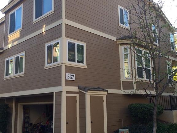 Back of townhome showing garage and further abundant windows