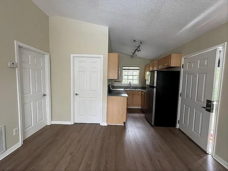 Efficient kitchen with ample cabinetry, full-size refrigerator, and a window over the sink for everyday convenience.