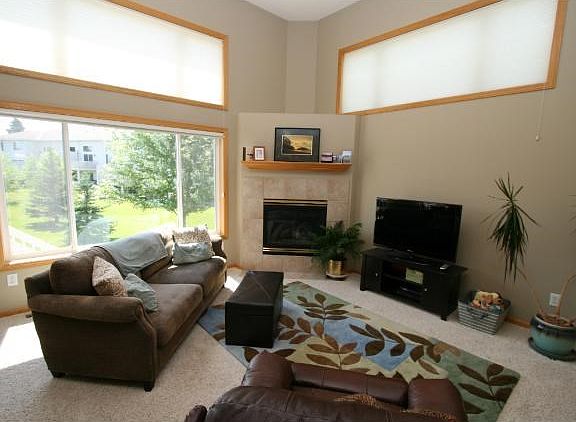 What a living room!! Towering ceilings, gas fireplace and large windows that bring in an abundance o