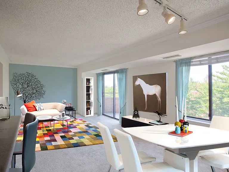 Living and dining areas with accent wall, balcony access and carpeted flooring