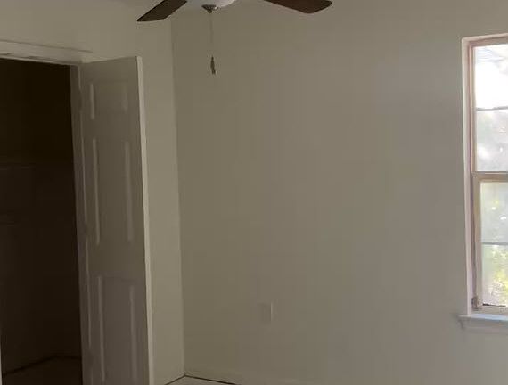 Spacious primary bedroom with roomy closet and modern ceiling fan.