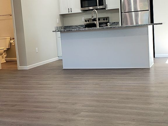 Large open living room with cathedral ceiling ceiling and ceiling fan. Look out your front window and see downtown.