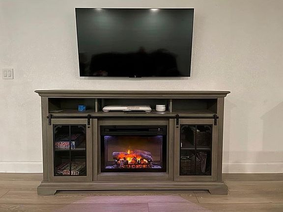 Main TV in living area with electric fireplace