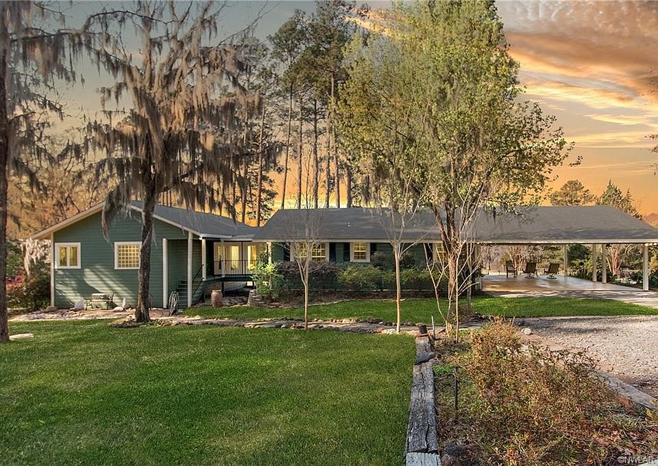 Home is nestled into the back of the subdivision which adds to the peaceful feeling. Over four acres with plenty of parking, storage buildings and room to play. Moss covered trees, large stones in the dry river bed and beautiful landscaping with azaleas a