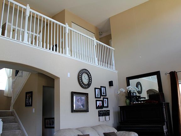 View from dining area; vaulted ceiling over living room. Front entry to left, garage entry behind wall with pictures; stairs to finished basement/Room #4 shown next to wall with pictures