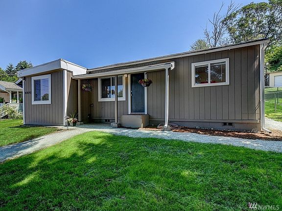Front view of the house with new gravel paths and landscape lighting for easy walking around the home.