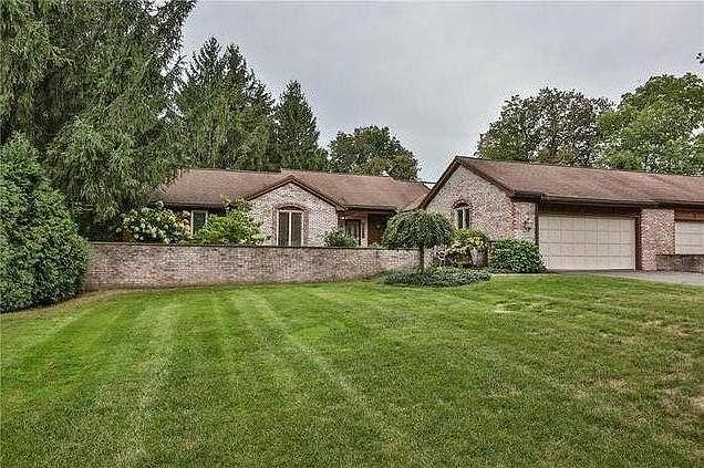 Front of house from street with large lawn and driveway.