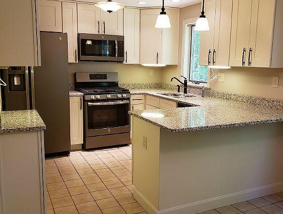 Stunning kitchen with dark stainless appliances, recessed lighting, granite countertops and more!