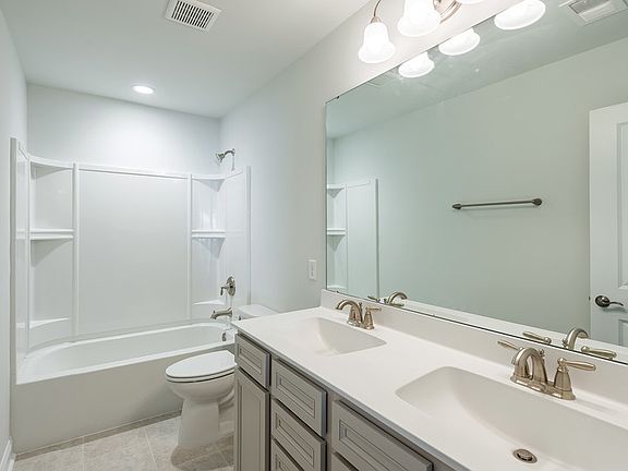 Guest Bathroom with dual-sink vanity and shower with tub