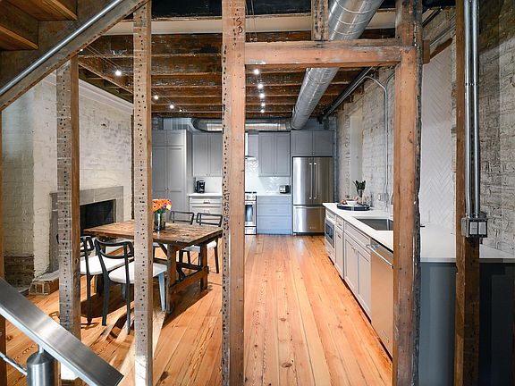 Exposed original wall studs, standing in entry looking into kitchen.