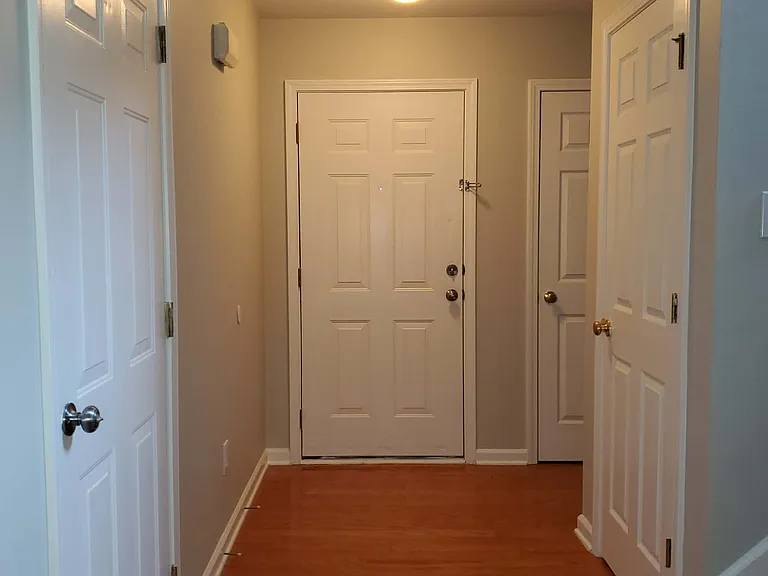 View of front door with interior access to garage.