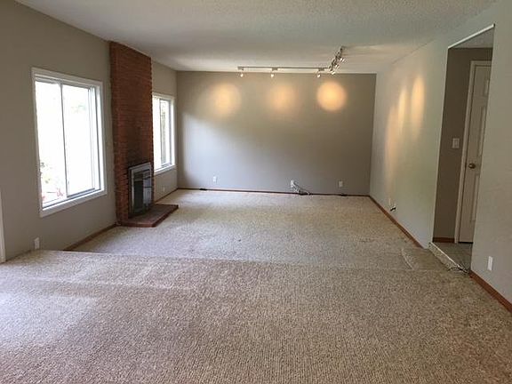 step-down living room with wood-burning fireplace