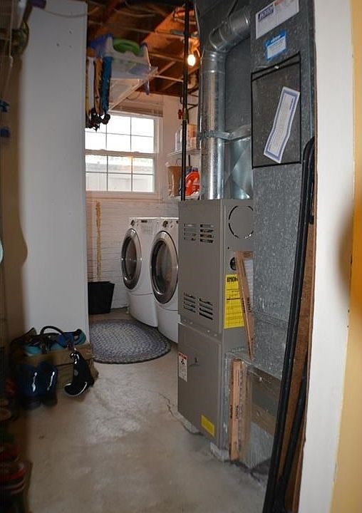 Light filled lower level laundry through white door at the bottom of steps.