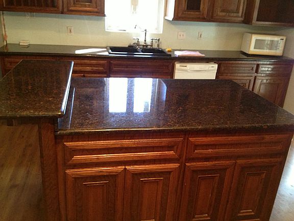 Large island with granite countertops and extra ledge for sitting space