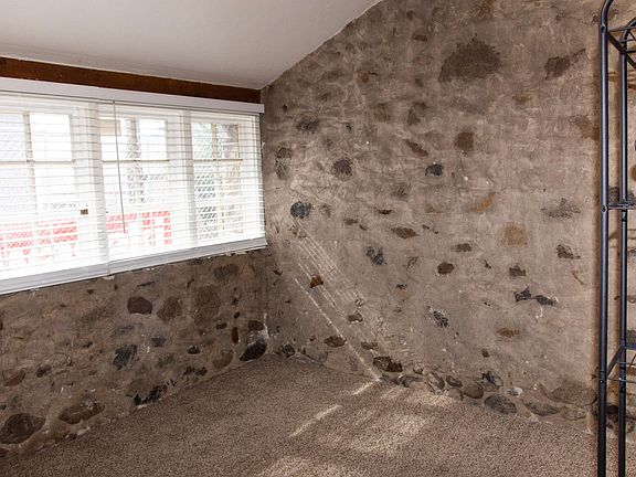 Spacious bedroom looks onto private yard. The original stonework is visible throughout the apartment.