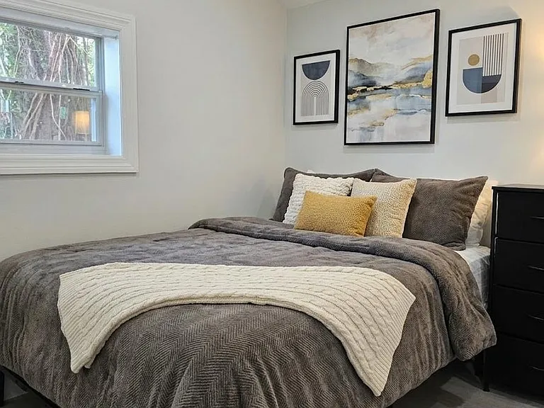 Well-appointed bedroom with a full bed, dresser storage, and window for natural light, plus efficient mini-split A/C.