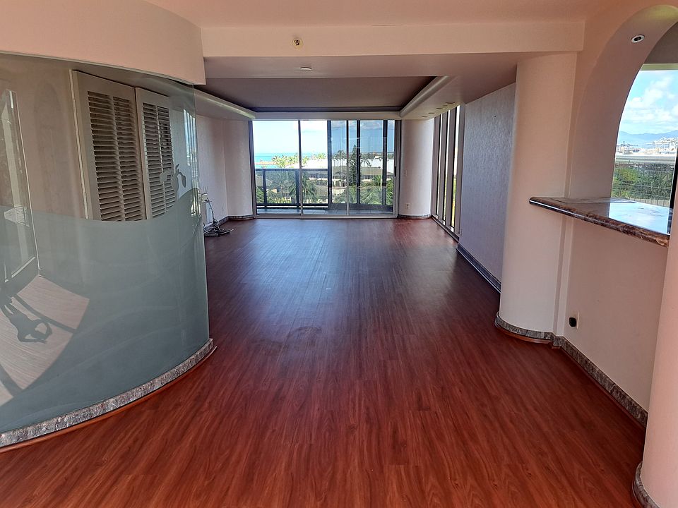 Dining area with Kitchen on the right and Entry on the left. Living area and balcony in the background
