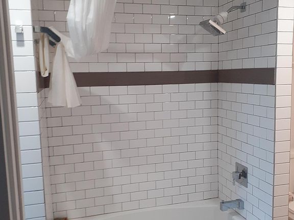 Bathroom with ceramic tile and modern bath/shower.