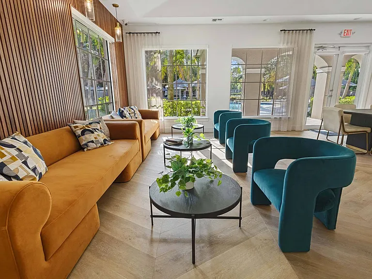 Relax in the vibrant lounge, featuring a cozy yellow couch, a green chair, and a stylish coffee table for the perfect space to unwind or entertain.