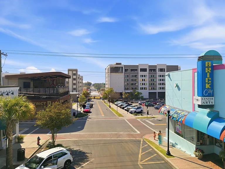 Street-facing view in a lively neighborhood with nearby shops, sidewalks, and convenient access to local amenities.
