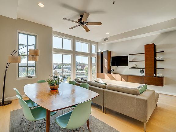 Spacious Living and Dining Area. The open floor plan, high ceilings, modern ceiling fans, and wood floors located throughout offers visual and aesthetic appeal. Built in wall unit stays with the property.