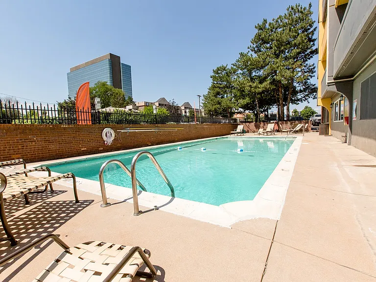 Sparkling outdoor pool with skyline views and lounge chairs
