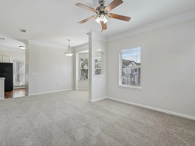 Bright and spacious living area with modern ceiling fan, open floor plan, and large windows for natural light. Bright and spacious living area with modern ceiling fan, open floor plan, and large windows for natural light.