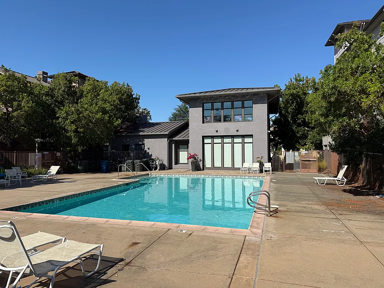 The resort-like community pool features a sparkling pool with lounge chairs.