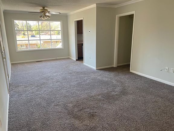 Living room view with access to garage on left and kitchen and hallway on right.