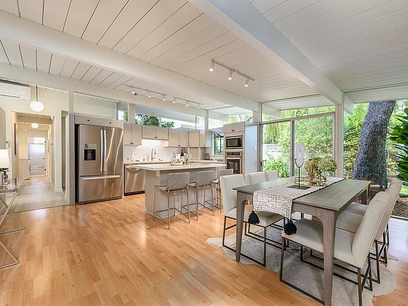 Kitchen features stainless steel appliances, quartz countertop with an island breakfast bar next to the dining room.