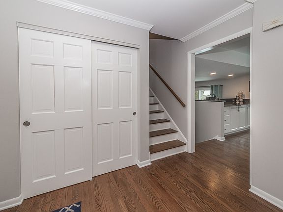 Foyer closet and oak staircase.